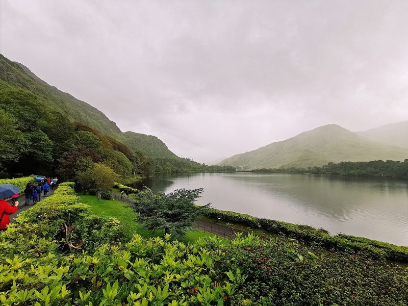 Rain over a lake and green hills